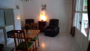 a living room with a table and chairs and a lamp at Gite Les Cigales in Labeaume