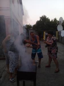 a group of people standing around a grill at Villa Jakos Paradise in Batumi