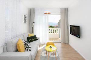ein Wohnzimmer mit einem weißen Sofa und einem TV in der Unterkunft Villa Nono in Podstrana