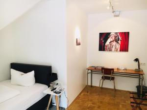 a bedroom with a bed and a desk with a painting at Dieckmann's Hotel in Dortmund