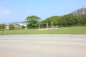 a playground in a park with a swing at Reighton Sands 2 in Filey