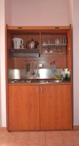 una cocina con armarios de madera con ollas y sartenes en Venetia Studios, en Perdika