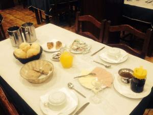 a table with plates of food and orange juice on it at O Pimpao in Geres