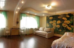 a bedroom with a couch and a painting of flowers at Квартира на проспекте Александра Поля с ромашками (Apartment on the Oleksandra Polia avenue with chamomiles) in Dnipro