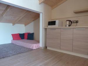 a small kitchen with a bed and a microwave at Guest house LETTO in Gagra