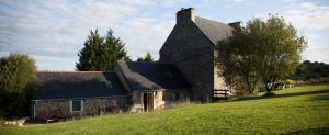 an old stone church on a grassy hill at La Colline des Renards in Locmaria-Berrien