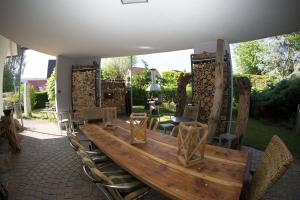 カンダーンにあるAvantgarde Livingの大きな木製テーブルと椅子付きのパティオ