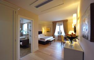 um quarto de hotel com uma cama e uma sala de estar em Hotel Palazzo San Lorenzo & Spa em Colle Val D'Elsa