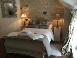 a bedroom with a bed with towels on it at La douceur Angevine in Montreuil-Bellay