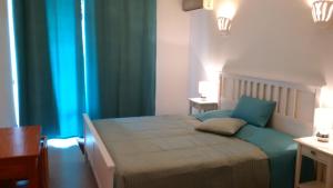 フェラグドにあるCasa Bele Algarveのベッドルーム1室(青いカーテン付きの大型ベッド1台付)
