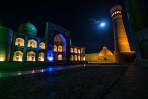 a night view of a building with a mosque at Al Bukhari Boutique Hotel in Bukhara