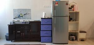 eine Küche mit einem Kühlschrank und lila Schubladen in der Unterkunft Fahaz Kamunting Taiping in Taiping