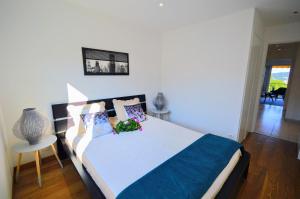 um quarto com uma cama com um edredão azul e branco em Villefranche center Bay & Port Sea view front em Villefranche-sur-Mer