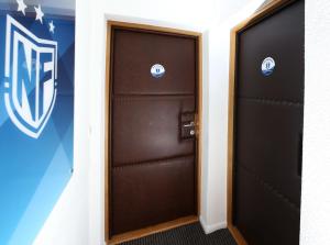 two doors in a locker room with a philadelphia flyers logo at NFM Apartman in Osijek
