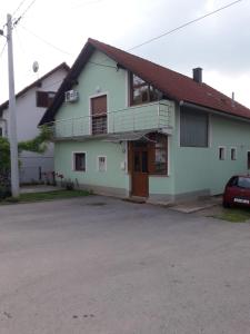 uma casa branca com uma varanda e uma entrada em Apartman Patrik em Slunj