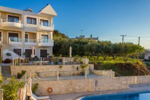 a villa with a swimming pool and a house at Esthisis Suites Chania in Platanias