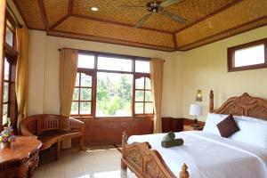 A bed or beds in a room at Ganesha Ubud Inn