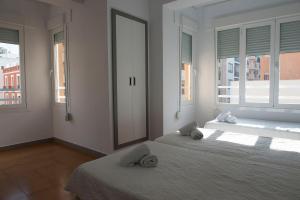 1 dormitorio con 2 camas y 2 ventanas en Hostal Ripoll Ibiza, en Ibiza