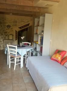 MontfrinにあるGite face à la rivière -proche du pont du Gard-のベッドルーム1室(ベッド1台、テーブル、椅子付)