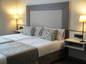 a hotel room with a large bed with two lamps at Pierre & Vacances Barcelona Sants in Barcelona