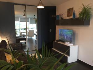 a living room with a flat screen tv on a cabinet at Tu Casa parking fibre optique Netflix in Saint-Raphaël