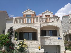 a house with a balcony on top of it at Apartments Benika in Bol