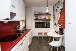 a kitchen with white cabinets and a red counter top at Utopia Home Alameda in Seville