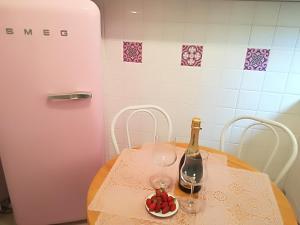 - une table avec une bouteille de vin et un bol de fruits dans l'établissement Appartamento Bellavista, à Sanremo
