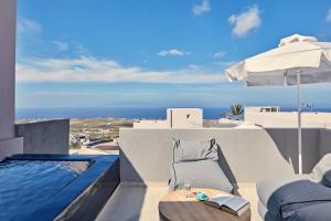 a hotel room with a pool table and chairs at Elysian Santorini in Oia