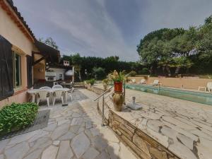 a patio with white tables and chairs and a pool at Villa Bruyere in Antibes
