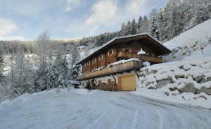 ein Blockhaus im Schnee mit Garage in der Unterkunft Sonnenplatzl im Zillertal in Ramsau im Zillertal