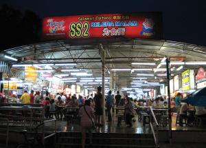 een groep mensen die rond een food court loopt bij Fivehouz Guest House in Petaling Jaya