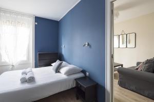 a blue bedroom with a bed and a couch at Côté Rivière in Rennes