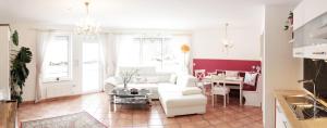 Fricks Appartement في Dölsach: غرفة معيشة مع أريكة بيضاء وطاولة