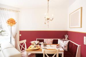 ein Esszimmer mit einem Tisch und einer roten Wand in der Unterkunft Fricks Appartement in Dölsach