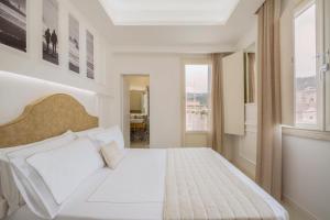 sypialnia z białym łóżkiem i oknem w obiekcie Townhouse Tropea w Tropei