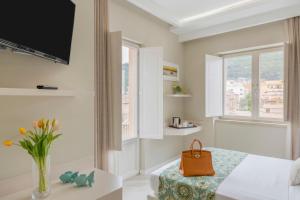 Pokój z łóżkiem i wazą z kwiatami w obiekcie Townhouse Tropea w Tropei