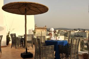 a table and chairs with a blue table and an umbrella at Hotel Riad Ben Atar in Essaouira