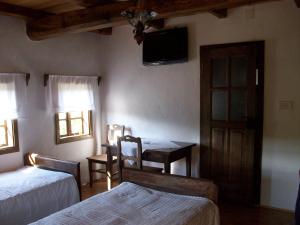 - une chambre avec 2 lits, une table et une télévision dans l'établissement Ethno Village Stara Lonja, à Lonja
