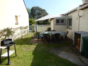 a patio with a table and chairs in a yard at Résidence Floria in La Baule