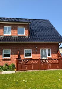 a red brick house with a black roof at Redewischer Str.23e in Boltenhagen