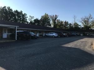 un estacionamiento con autos estacionados frente a un edificio en Angola Motel, en Angola-on-the-Lake
