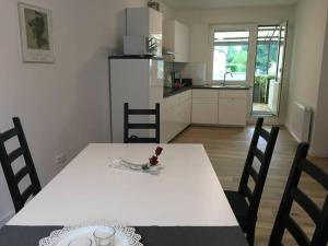 una cocina con una mesa blanca con sillas y un Sidx Sidx de mesa blanca en Ferienhaus Rur, en Hückelhoven