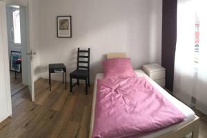 1 cama con edredón rosa en una habitación en Ferienhaus Rur, en Hückelhoven
