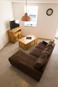 a living room with a brown couch and a table at Gîte de l'hamelinaie in Montanel