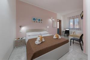 a bedroom with two teddy bears sitting on a bed at Tra la montagna e il mare in San Vito lo Capo