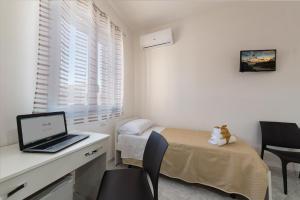 a bedroom with a desk with a laptop computer on it at Tra la montagna e il mare in San Vito lo Capo