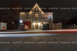 a house with lights on the front of it at night at Hotel Hottey in Kyiv