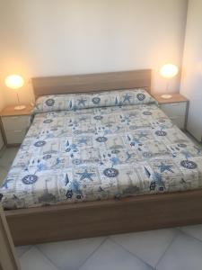 ポルト・エルコレにあるdelizioso appartamento con terrazzettaのベッドルーム1室(青と白のキルトのベッド1台付)