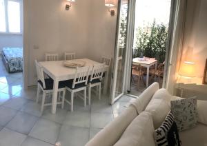 sala de estar con mesa blanca y sofá blanco en delizioso appartamento con terrazzetta, en Porto Ercole